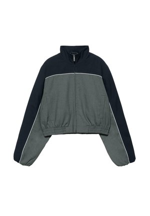 Krótka kurtka z wysokim kołnierzem, z przodu zamek błyskawiczny, elastyczny pas, w kolorach blokowych: ciemny granat i szary, z białą lamówką na rękawach i na klatce piersiowej.