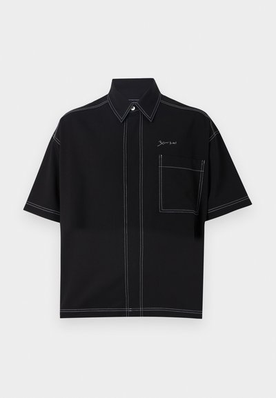Black short-sleeve shirt with a structured collar, featuring contrasting white stitching and a left chest pocket. Brand logo on the front.