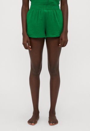 Shorts verts froissés avec une taille élastique, présentant une texture lisse et une coupe décontractée. Conçus pour le confort et la respirabilité.
