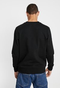 Czarna bluza z okrągłym dekoltem, ściągaczami na mankietach i dole, wykonana z miękkiego materiału. Tył z gładkim wzorem, odpowiednia do codziennego noszenia.