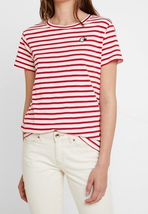 Punainen ja valkoinen raidallinen T-paita lyhyillä hihoilla, pyöreällä kaula-aukolla ja mustalla brodeeratulla pandatietokannalla rinnassa. Yhdistetty valkoisiin housuihin.