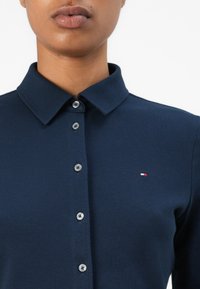 Polo shirt navy con colletto classico, patta con cinque bottoni e piccolo logo multicolore sul lato sinistro. Tessuto testurizzato.