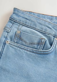 Jeans din denim de culoare albastru deschis, cu un buzunar posterior, accente cusute și nituri metalice. Textură moale și design flexibil.