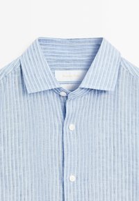 Camicia a righe blu chiaro realizzata in tessuto testurizzato, dotata di colletto a punta, chiusura a bottoni e tre bottoni bianchi sulla patta.
