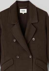 Veste en laine marron à double boutonnage, avec de larges revers, deux boutons et des poches latérales. Étiquette indiquant "BZB" avec la taille "S".