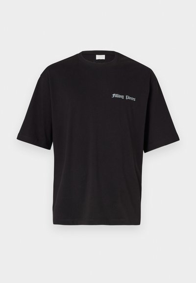 Must must värvi t-särk lühikeste varrukatega, ringikujuline kaelus ja sinine "Filling Pieces" logo trükitud vasakul rinnal. Sile tekstuur.