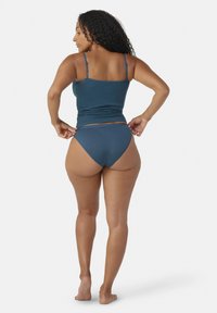 Teal linne med tunna band, kombinerat med teal högmidjade bikiniunderdelar. Tillverkat av bomull, figurnära design, minimalistiska detaljer.