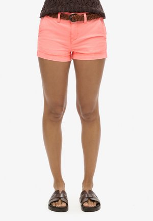 Shorts corail éclatants avec un ourlet roulé, fabriqués en tissu léger. Associés à une ceinture tressée marron et des sandales plates marron.