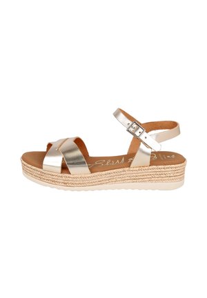 Sandalia metálica dorada con punta abierta, correa en el tobillo, cierre de hebilla y suela plataforma estilo esparto trenzado.