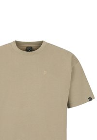 Beige katoenen t-shirt met een ronde halslijn, korte mouwen en een klein logo op de borst. Heeft een label op de mouw. Gladde textuur.