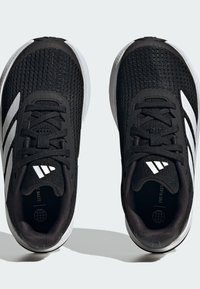 Scarpe da atletica nere con una parte superiore in mesh testurizzato, strisce bianche e lingua imbottita. Presentano lacci neri e una suola ammortizzata per supporto.