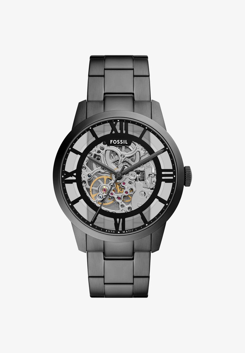Black metal Fossil wristwatch with skeleton dial, visible gears, Roman numerals, and three hands showing the time.