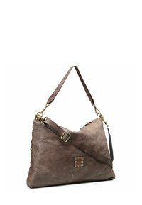 Bolso de hombro de cuero marrón con correa ajustable, herrajes en tono dorado y un parche de logo cuadrado con tachuelas en la parte delantera.