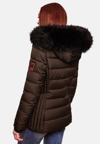 Brown puffer jacket with a black faux fur hood, quilted design, and a logo patch on the sleeve. Smooth texture and fitted silhouette.
