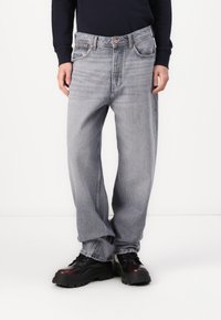 Heledad kergelt kulunud denim teksad, millel on mugav lõige ja sirged sääred, kõrge vöökoht, neli taskut ja vasknõeltega kaunistused.