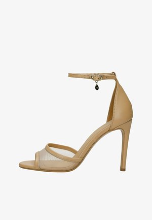 Beige hoge hak sandaal met enkelbandje, open teen, mesh voorkant en klein decoratief hangertje op de gesp.