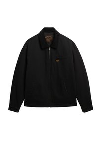 Veste noire avec une fermeture éclair, un col à pression et deux poches latérales. Présente une étiquette logo discrète sur la poitrine et un tissu texturé.