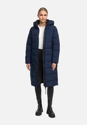 Lange, gevoerde marineblauwe jas met een capuchon, voorzien van een ritssluiting aan de voorkant, gestikte panelen en zwarte accenten. Draag over een witte top en zwarte jeans.