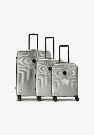 Drei silberne Hartschalenkoffer mit schwarzen teleskopischen Griffen und vier Rädern, nebeneinander angeordnet von größtem zum kleinsten.