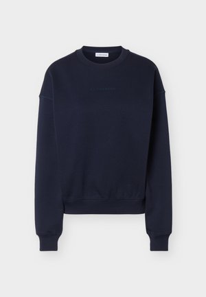 Sweat-shirt à manches longues bleu marine foncé à encolure ras-du-cou, avec poignets et ourlet côtelés, présentant un logo discret "J.LINDEBERG" sur la poitrine et à l'intérieur du col.