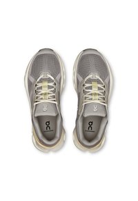 Zapatillas deportivas grises con parte superior de malla y acentos beige. Logo reflectante en la lengüeta y una suela acolchada para soporte y comodidad.