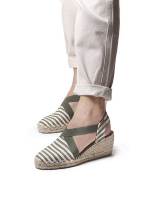 Green and white striped espadrille wedges with a jute sole, featuring crisscross straps and an open heel design.