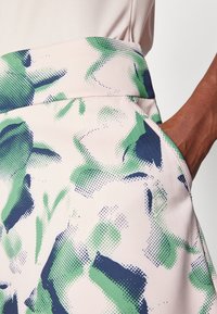 Kjol med blommönster i pastellrosa med gröna och marinblå detaljer. Har en mjuk textur, sidofickor och en figursydd midjeresår.