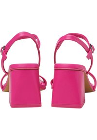 Sandali con tacco a blocco rosa, caratterizzati da ampie cinghie e fibbie alla caviglia regolabili. Materiale sintetico liscio, tacchi quadrati e dettagli minimi.