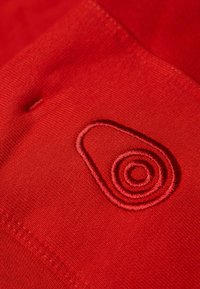 Červená textilie s vyraženým logem avokáda a spirálov�ým designem ve kontrastní nití na hladkém, strukturovaném povrchu.
