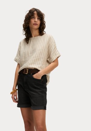 Linneblandning, kortärmad topp med kräm- och beige ränder; ihop med mörk denimshorts och ett flätat brunt bälte, med uppvikta ärmslut.