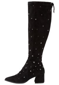 Korkea musta mokkajalkine, jossa on blokki korko, koristeltu erilaisilla pienillä hopeisilla niiteillä ja tähdenmuotoisilla koristeilla.