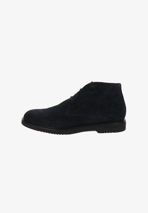 Stivali alla caviglia in suede blu navy con punta arrotondata, suola in gomma nera bassa e semplice dettaglio di allacciatura sul davanti per la chiusura.
