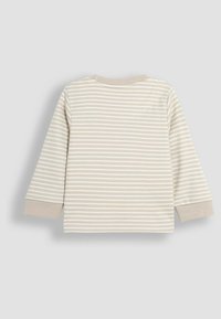 Beige kinderhemd met lange mouwen en horizontale witte strepen, voorzien van een ronde halslijn en zachte katoen stof.