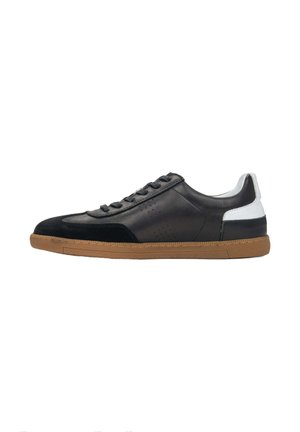Black leather sneaker with suede accents, rubber gum sole, and white heel counter. Features black laces and perforated detailing.