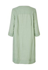 Jasnozielona sukienka lniana o luźnym kroju. Posiada trzy czwarte rękawy oraz okrągły dekolt, sięgająca do połowy uda.