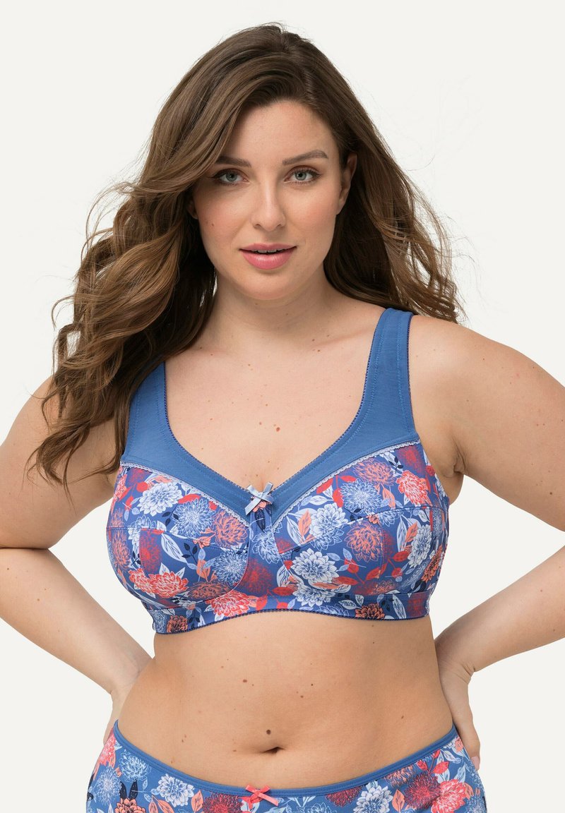 Reggiseno con motivo floreale su base blu, realizzato in tessuto morbido, con spalline larghe e un fiocco decorativo al centro. Design leggero e traspirante.