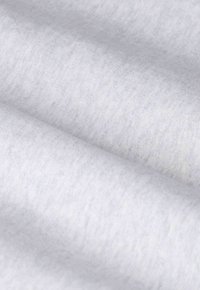 Tissu gris clair avec une surface douce et légèrement texturée. Le matériau semble lisse avec un léger motif chiné.