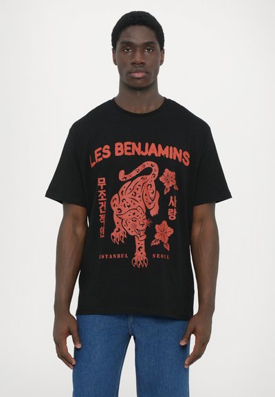 Black cotton T-shirt featuring red graphic of a tiger and floral design, with text in English and Korean. Relaxed fit with short sleeves.