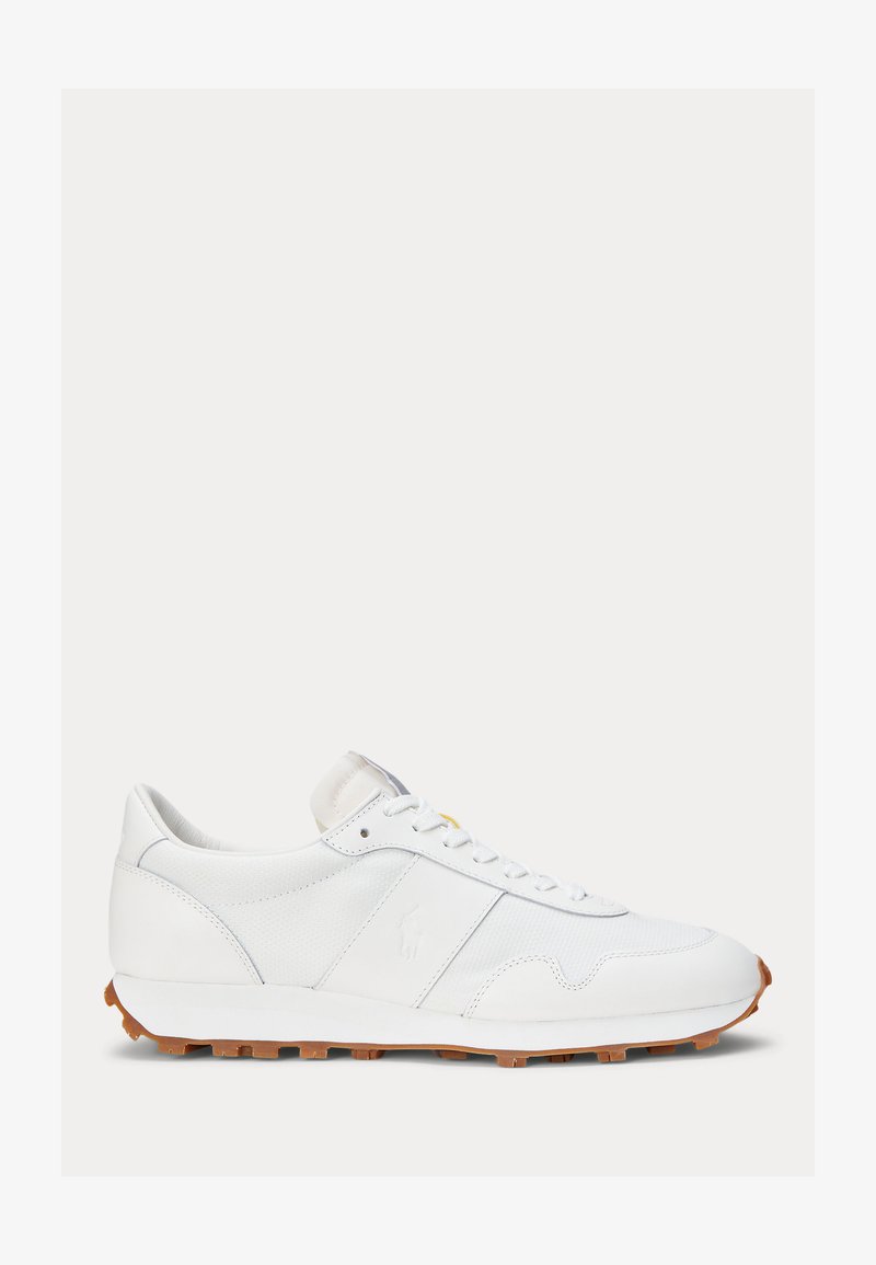 White low-top sneaker with white laces, textured leather upper, and brown lugged sole, shown in side profile on a plain background.