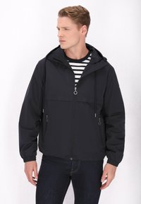 Zwart windjack met capuchon, rits aan de voorkant, zijzakken en elastische manchetten. Heeft een lichtgewicht, gladde textuur.