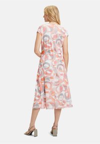 Midi-Kleid mit Blumenmustern und kurzen Ärmeln, das runde Formen in Koralle, Grau und Weiß auf einem leichten Stoff zeigt. Mit einer Taillenbetonung.