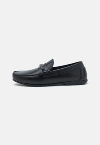 Sorte skinn loafers med søm detaljer og slip-on design. Skoene har en glatt tekstur og en lavprofil gummisåle.