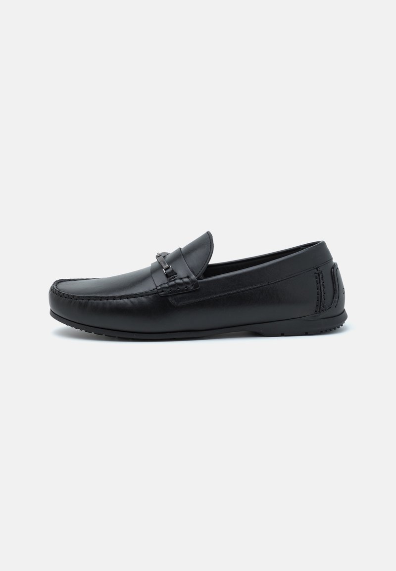 Sorte skinn loafers med søm detaljer og slip-on design. Skoene har en glatt tekstur og en lavprofil gummisåle.