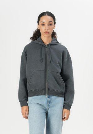 Dark gray zip-up hoodie with a hood, kangaroo pocket, and ribbed cuffs. Soft fabric with a relaxed fit and visible stitching details.