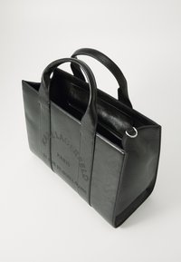 Zwarte leren tote bag met twee bovenhandvatten, reliëf voorlogo, gestructureerde vorm en een ritsvak aan de binnenkant.