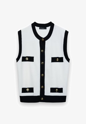 Gilet bianco senza maniche lavorato a maglia con bordi neri, sei bottoni dorati e quattro patte di tasca nere con dettagli a bottoni dorati.