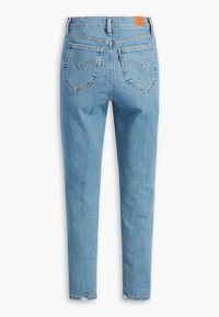 Ljust blå denimjeans med slim fit, med hjärtformade bakfickor och en brun läderlapp på midjebandet. Ren fåll.