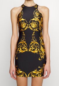 Černé bezramínkové šaty se zlatým barokním vzorem, s vysokým výstřihem a přiléhavým střihem, vyrobené z elastického materiálu pro pohodlí.