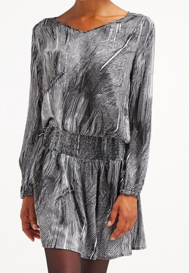 Dlouhé šaty s černobílým pruhovaným vzorem. Mají gumičkový pas a volný střih, s výstřihem do V a splývavou texturou.