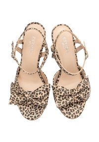Sandały na wysokim obcasie w leopardzim wzorze z kokardką na palcu. Posiadają regulowane zapięcia w kostce oraz beżową, teksturowaną wkładkę.